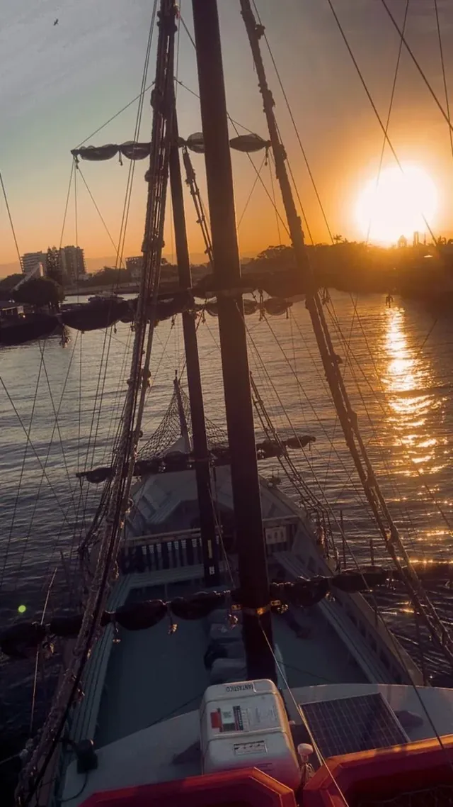 Convés e mastros do navio pirata vistos de cima, com o sol se pondo sobre o Guaíba
