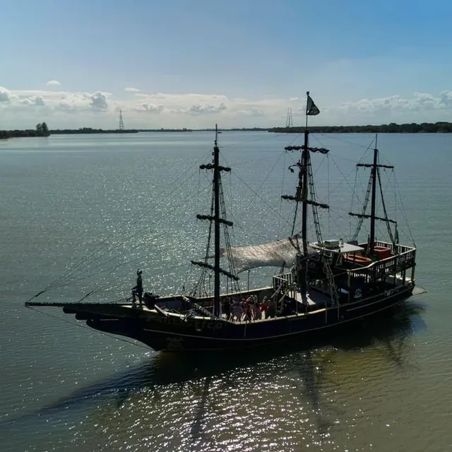 Navio pirata com passageiros navegando no Guaíba em dia de sol, visto de cima