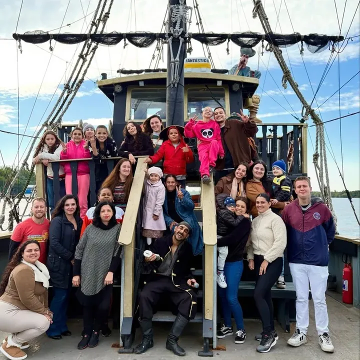 Grupo de convidados reunido no convés do navio pirata durante um evento social